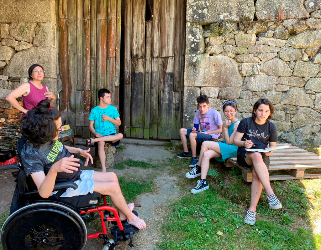 
Fotografía. Vista frontal de 5 integrantes de 'Estudiantes por la inclusión' y una persona adulta juntos en un espacio al aire libre. 