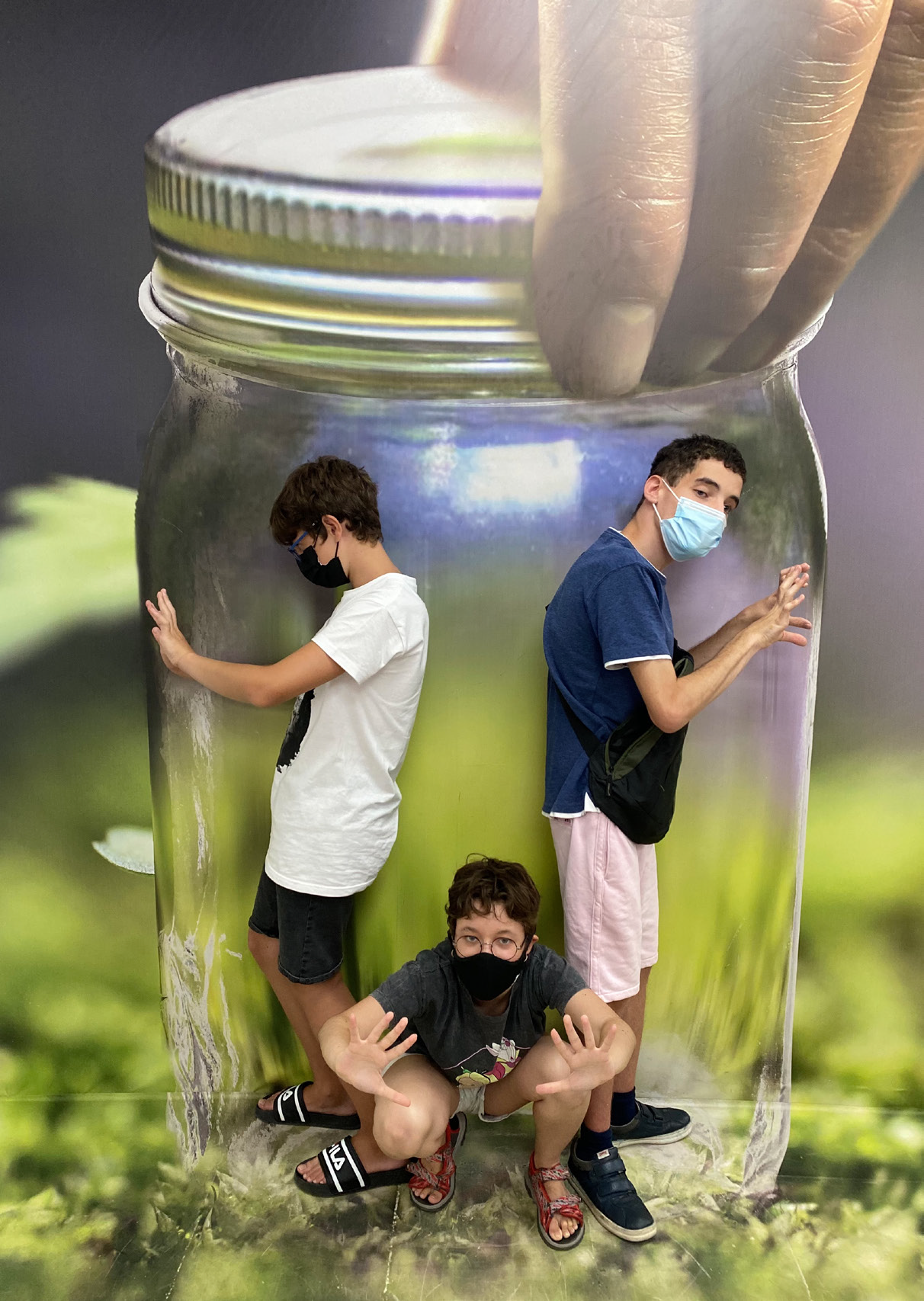 Fotografía. Collage. Tres jóvenes del grupo  'Estudiantes por la inclusión' atrapados en un bote de cristal cerrado.