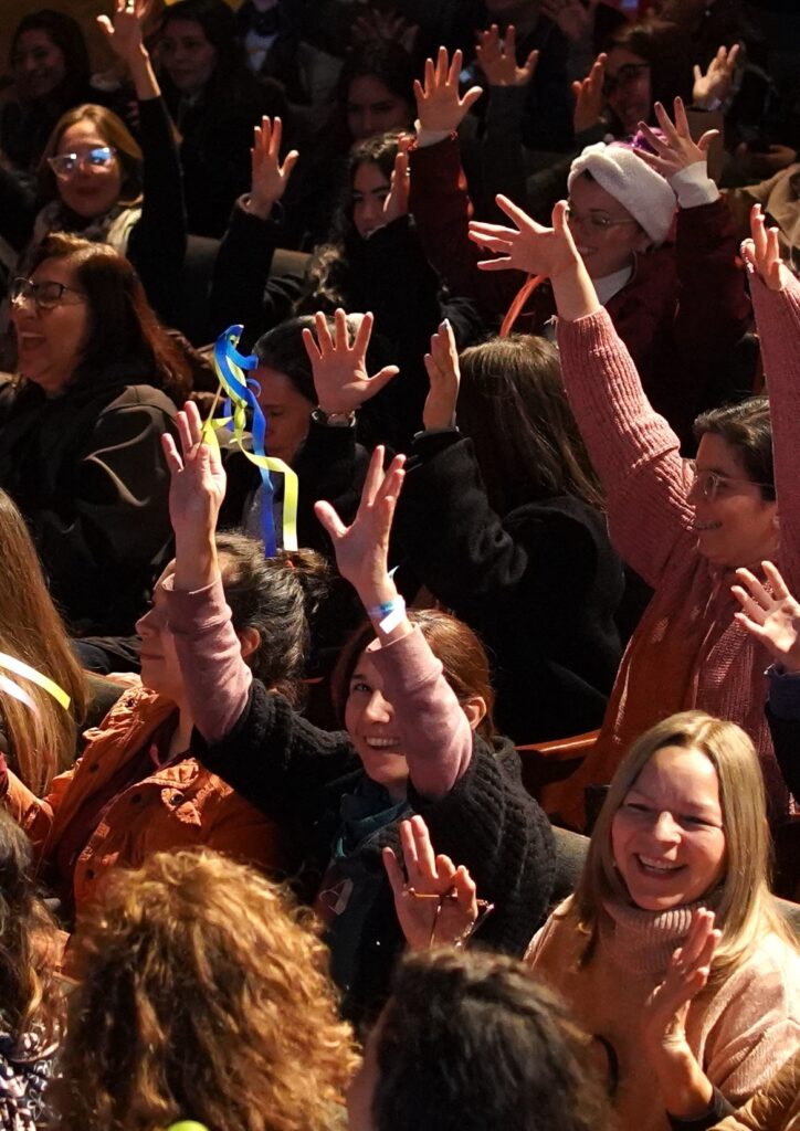 Participantes de un evento (ION 2024, Paraguay) en un momento festivo, con las manos levantadas y riendo.