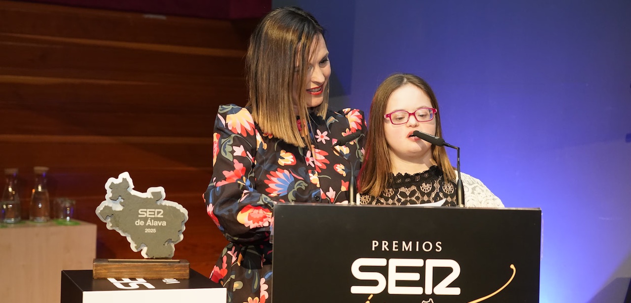 Indira pronuncia su discurso en un atril en el que se lee "Premios SER", junto a su madre, que escucha atenta.