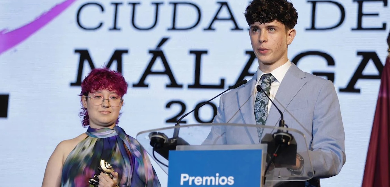 Darío pronuncia su discurso mientras Malena escucha con el premio Ciudad de Málaga en las manos.