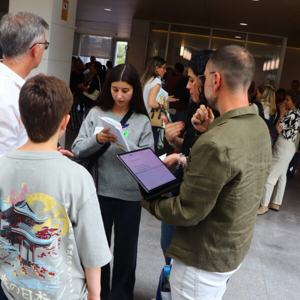 Fotografía. Facilitadores conversan con estudiantes sobre el contenido del taller, y toman notas.