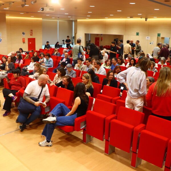 Fotografía. Conversación durante una asamblea en el Salón de actos.