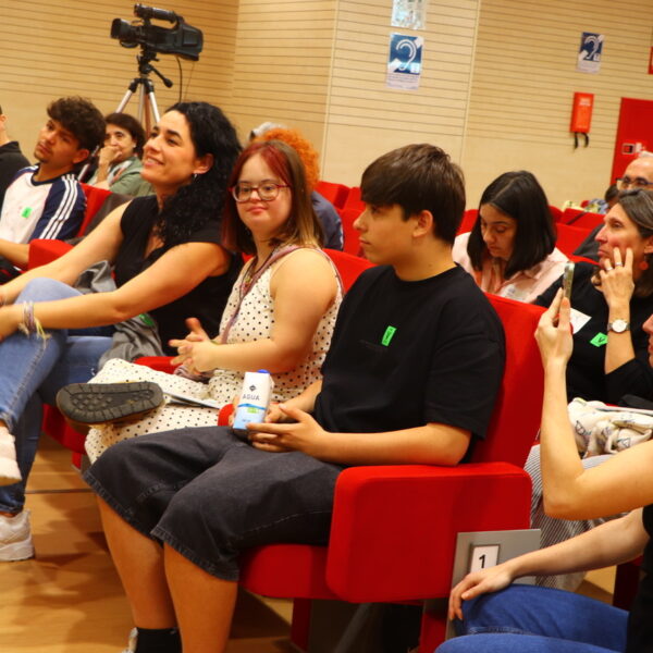 Fotografía. Varias personas escuchan sentadan en el salón de actos durante una asamblea.