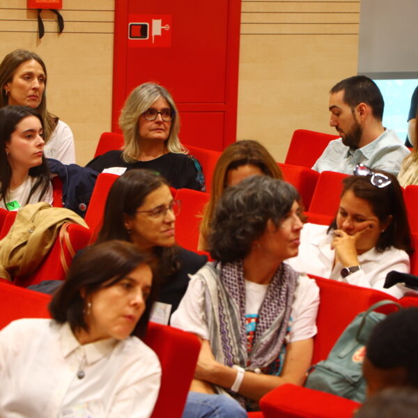 Fotografía. Varias personas escuchan sentadan en el salón de actos durante una asamblea.