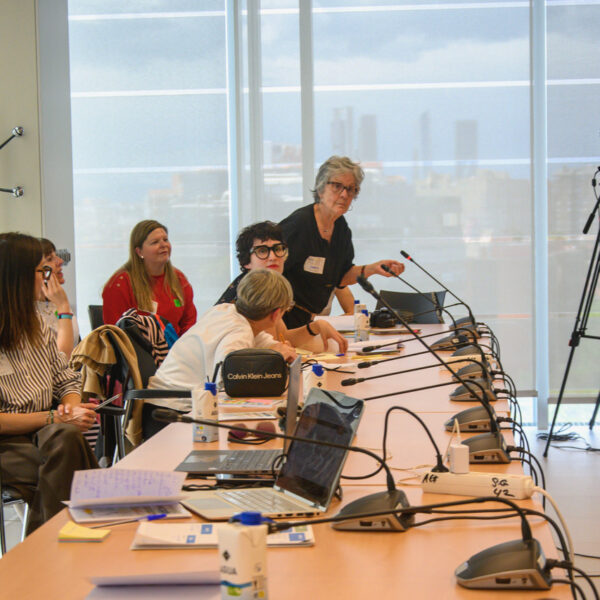 Fotografía. Durante un taller, una participante toma la palabra, en pie, mientras el resto escucha.