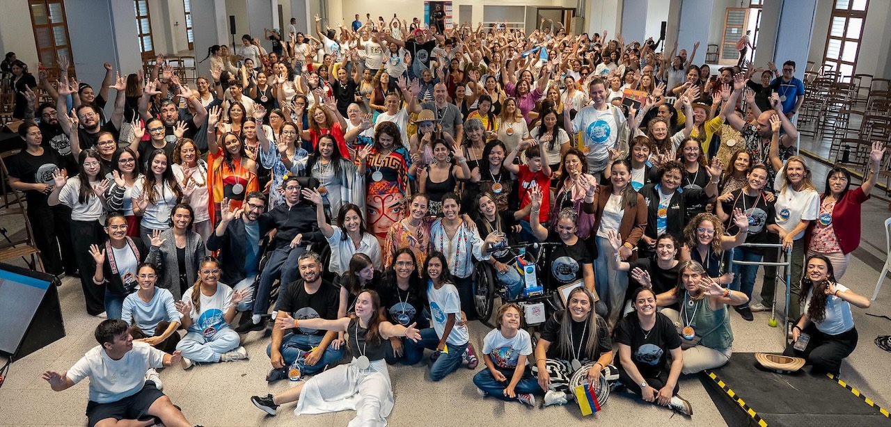 Fotografía en la que centenares de personas, con actitud sonriente, miran a la cámara con los brazos en alto, tras finalizar el 1er Congreso Iberoamericano de Educación Inclusiva como Movimiento Social